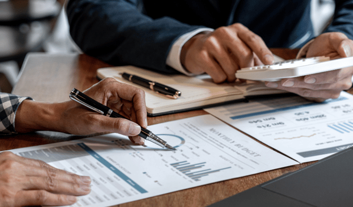 Businessmen calculating and reading charts